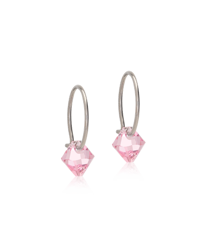 Pair of pink crystal earrings on silver hooks against a white background