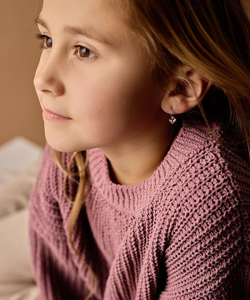 Young girl wearing a pink sweater with a soft focus background