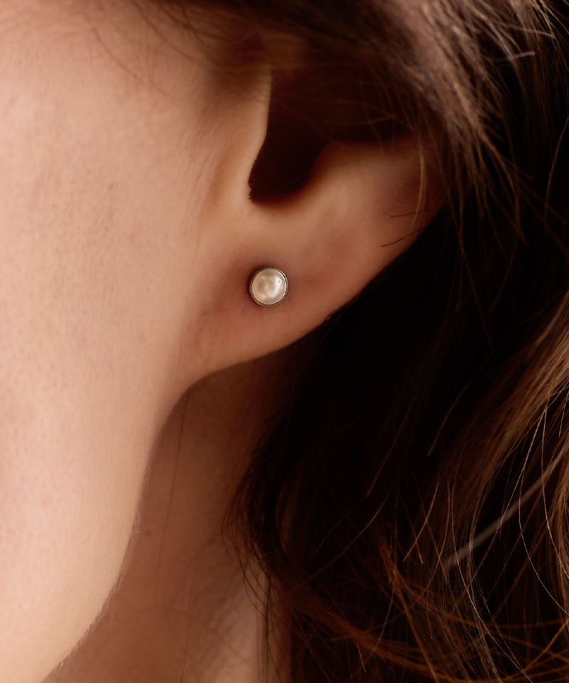 Silver titanium bezel pearl earrings on model 